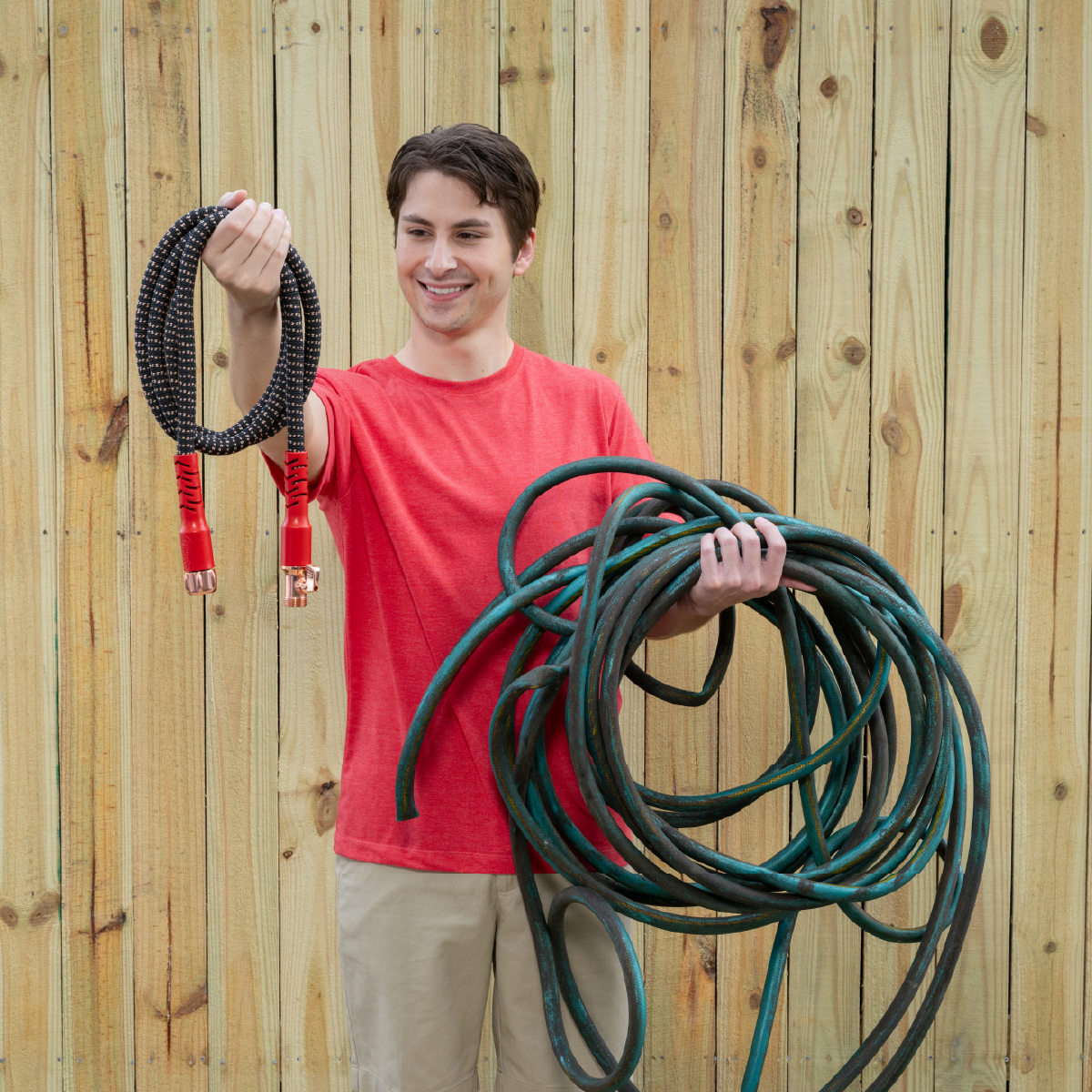 A demonstrator holding a compact Copper Head hose alongside a conventional garden hose